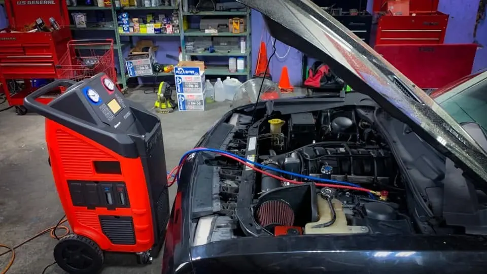 Máquina de servicio de A/C conectada a un motor en iShop