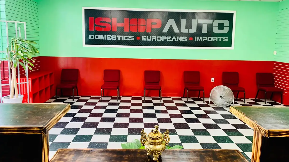 The iShop waiting room with red chairs and a checkered floor